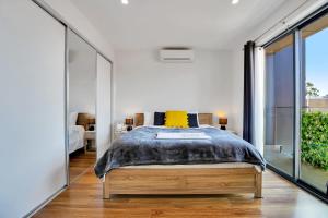 a bedroom with a bed with a yellow pillow at Cozy Townhouse in Werribee centre in Werribee