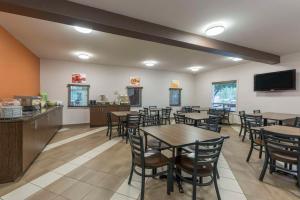 un ristorante con tavoli e sedie e una TV a schermo piatto di Quality Inn Airport a Moncton