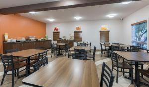 una sala da pranzo con tavoli e sedie in legno di Quality Inn Airport a Moncton