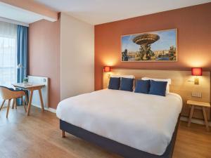 een hotelkamer met een groot bed en een bureau bij Aparthotel Adagio Paris Boulogne in Boulogne-Billancourt