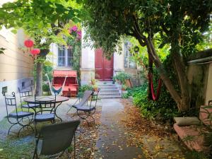 um pátio com uma mesa e cadeiras e uma porta vermelha em La Maïoun Guesthouse em Nice