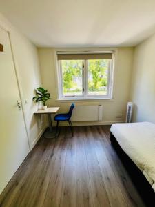 Schlafzimmer mit einem Bett, einem Schreibtisch und einem Fenster in der Unterkunft 3 Sk Apt With Roof Terracespoorparkeftelinguvt in Tilburg