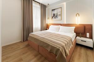 a bedroom with a large bed with white sheets at Solridge Aparthotel in Tbilisi City