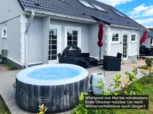 LütowFerienhäuser Insel Usedom Haus Mila 6 - Blick aufs Achterwasser! Whirlpool und Sauna的房屋前甲板上的热水浴池