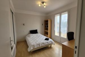 una camera con un letto bianco e una finestra di BEL appartement T5 NEUF avec 4 chambres a Tarbes