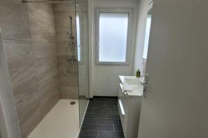 bagno con doccia, lavandino e specchio di BEL appartement T5 NEUF avec 4 chambres a Tarbes