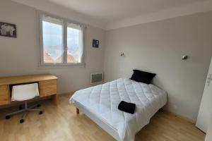 una camera con letto, scrivania e finestra di BEL appartement T5 NEUF avec 4 chambres a Tarbes