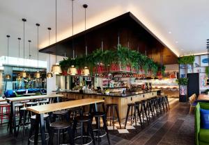 een bar in een restaurant met tafels en stoelen bij citizenM Miami South Beach in Miami Beach