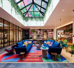 een lobby met blauwe banken en een kleurrijk tapijt bij citizenM Miami South Beach in Miami Beach