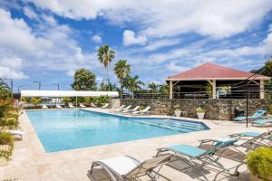 una piscina con sedie e un edificio di Port de Plaisance Resort, Trademark Collection by Wyndham a Philipsburg