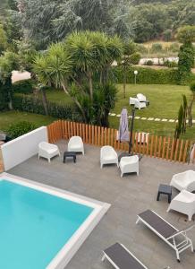 a group of chairs and a swimming pool at 3M Hostel & Suites in Alvaiázere