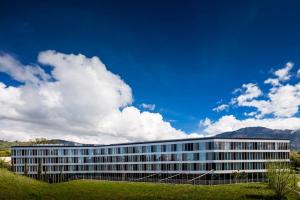 um grande edifício branco com montanhas ao fundo em Modern Times Hotel, Vevey, A Tribute Portfolio Hotel em Vevey