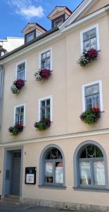 um edifício com janelas com vasos de flores em Pension Altstadt em Veimar