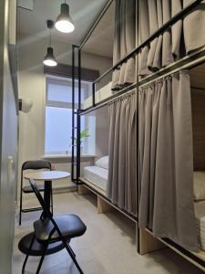 CAPSULE HOTEL & HOSTEL في خاركوف: غرفة نوم مع سرير بطابقين وطاولة وكرسي