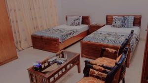 um quarto com 2 camas, uma mesa e uma cadeira em Hotel Royal Residency em Karachi