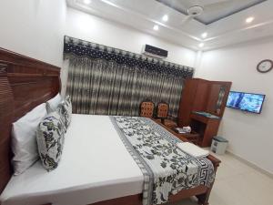 um quarto com uma cama grande e uma janela em Hotel Royal Residency em Karachi