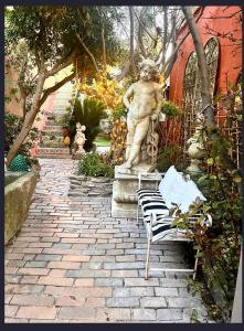 une passerelle en pierre avec une statue d'ours et un banc dans l'établissement Villa Romana, à Saint-Tropez