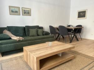 - un salon avec un canapé vert et une table dans l'établissement Maximi Loft - Ferien & Business, à Merseburg