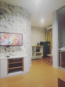 a living room with a tv on a stone wall at studio room seaview jomtien in Jomtien Beach