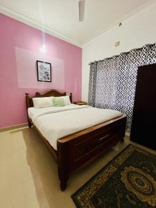 una camera con letto e parete rosa di Coorg New Dreamland Homestay and tent stay a Kushalnagar