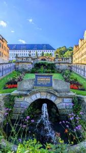 un puente de piedra sobre una fuente en un jardín en FeWo Urban Gotha - Apartment Orangerie - Am Schlosspark- Parken an der der Tür- Barrierefrei, 900 Meter zum Bahnhof - Wallbox, en Gotha