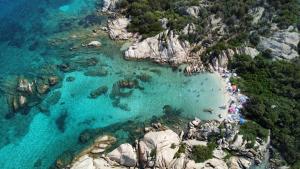 eine Luftansicht auf einen Strand mit Menschen im Wasser in der Unterkunft Case Vacanze Villa Rosita in San Teodoro