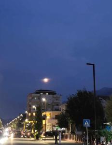 um edifício numa rua da cidade à noite em My Sky Përmet em Përmet