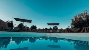 una piscina con sillas y sombrillas en una valla en Casa do Pastor - Escapadinha Rural com Vista Magnífica para a Serra - by Matias Nature, en Carragozela