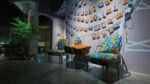 two chairs and a table in a room with pictures on the wall at Dao Bian Inn in Zhangjiajie