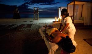 une femme debout à côté d'un homme allongé sur un lit dans l'établissement Sandy Haven Resort, à Negril