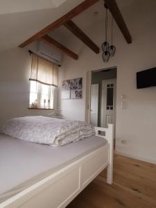 a bedroom with a white bed and a television at Schwarzwaldpanorama Doppelzimmer-WC in Ettlingen