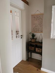 a hallway with a door and a table with baskets at Schwarzwaldpanorama Doppelzimmer-WC in Ettlingen