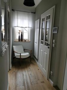 a hallway with a white chair and a window at Schwarzwaldpanorama Doppelzimmer-WC in Ettlingen