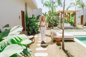 une femme debout en face d'une villa dans l'établissement Alma Bingin Boutique Hotel, à Uluwatu