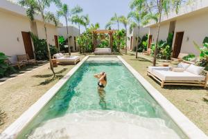 - une femme dans la piscine d'une villa dans l'établissement Alma Bingin Boutique Hotel, à Uluwatu