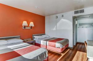 a hotel room with two beds with orange walls at Park Inn by Radisson, Fort Collins in Fort Collins