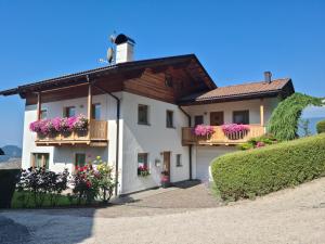 ein weißes Haus mit Blumen auf den Balkonen in der Unterkunft Apartment Sassun in Lajen