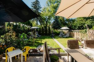 un jardin avec des chaises, des tables et des parasols dans l'établissement PauliDrei, à Leipzig