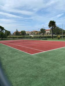 een tennisbaan met een tennisbaan bij Bonito Duplex en Gran URB Con PISCINA in Ajo