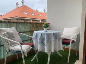 twee stoelen en een tafel met een tafelkleed op een balkon bij Bonito Duplex en Gran URB Con PISCINA in Ajo