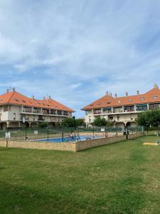 uitzicht op twee appartementsgebouwen en een zwembad bij Bonito Duplex en Gran URB Con PISCINA in Ajo