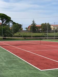 een tennisbaan met een net erop bij Bonito Duplex en Gran URB Con PISCINA in Ajo