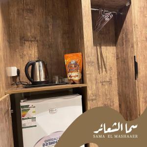 a room with a refrigerator and a shelf with a microwave at فندق الخلفاء الماسي in Makkah