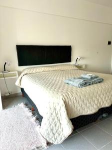 um quarto com uma cama com duas toalhas em Torre Cid Movistar Arena em Buenos Aires