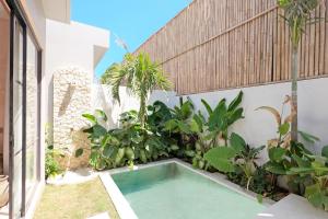 - une piscine dans la cour d'une maison ornée de plantes dans l'établissement Alma Bingin Boutique Hotel, à Uluwatu