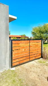 een houten hek in een tuin naast een huis bij Casitas Atlántida in Atlántida