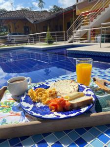 un piatto di cibo su un tavolo accanto a una piscina di Ecohotel Guaduales Pereira a Pereira