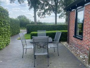 una mesa y sillas en un patio de ladrillo en Kindvriendelijk appartement de Hooge Stukken onder de rook van Groningen, en Eelde-Paterswolde