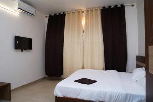 een slaapkamer met een bed met een zwart-wit gordijn bij Meridian Rooms and Service Apartment in Mysore