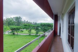 uma varanda com vista para um campo verde em Coorg Residency home stay em Kushālnagar